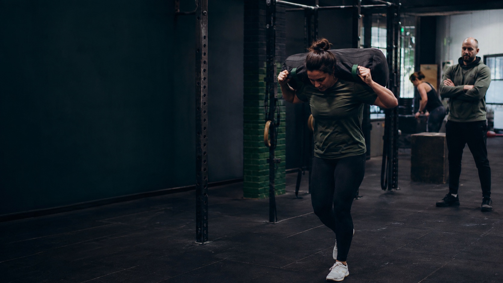 Gegenereerde documentaire trainingsscène met een atleet die gecontroleerd een zware sandbag draagt